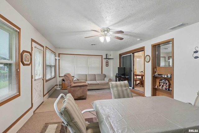 1119 14th St, Bettendorf, IA 52722 - dining room with ceiling fan, a textured ceiling, light colored carpet, and baseboards