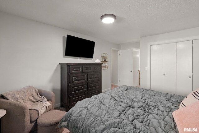 28013 230th St, Le Claire, IA 52753 - bedroom featuring baseboards, a closet, carpet floors, and a textured ceiling
