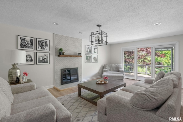 28013 230th St, Le Claire, IA 52753 - living room with a textured ceiling, light wood-style floors, baseboards, a chandelier, and recessed lighting