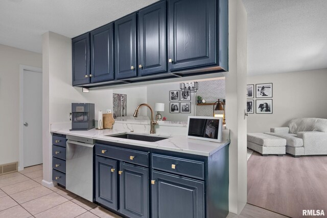 28013 230th St, Le Claire, IA 52753 - kitchen featuring blue cabinetry, dishwasher, a sink, and open floor plan