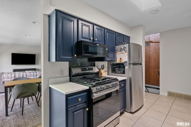 28013 230th St, Le Claire, IA 52753 - kitchen with appliances with stainless steel finishes, blue cabinetry, baseboard heating, and light countertops