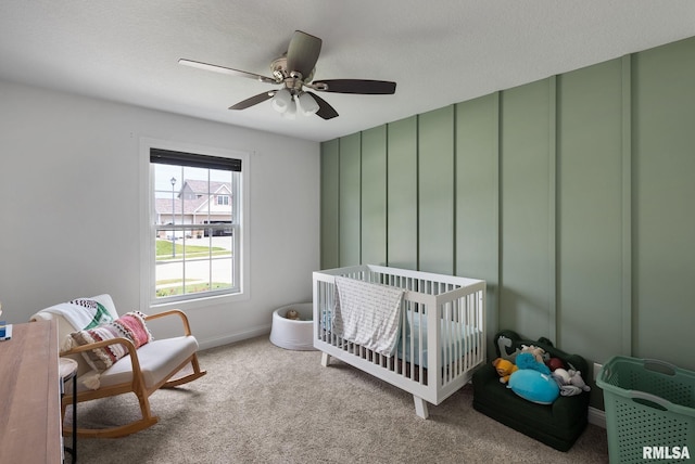 1625 W 71st St, Davenport, IA 52806 - bedroom with a crib, carpet floors, a ceiling fan, baseboards, and a decorative wall