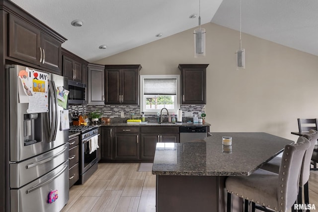 1625 W 71st St, Davenport, IA 52806 - kitchen with appliances with stainless steel finishes, a sink, vaulted ceiling, dark brown cabinets, and decorative backsplash