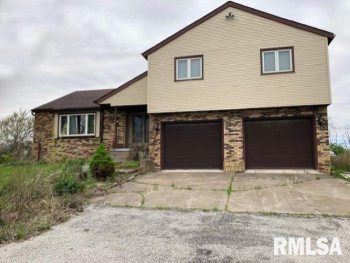 11630 81st St W, Taylor Ridge, IL 61284 - view of front of house with an attached garage, driveway, and brick siding