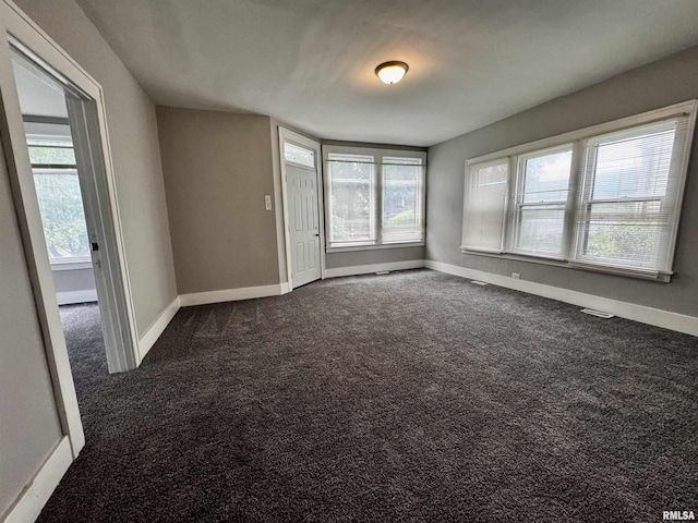 2107 N Marquette St, Davenport, IA 52804 - spare room with baseboards, healthy amount of natural light, and dark carpet