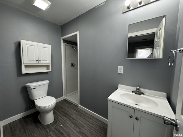 2107 N Marquette St, Davenport, IA 52804 - bathroom with toilet, vanity, wood finished floors, baseboards, and a shower
