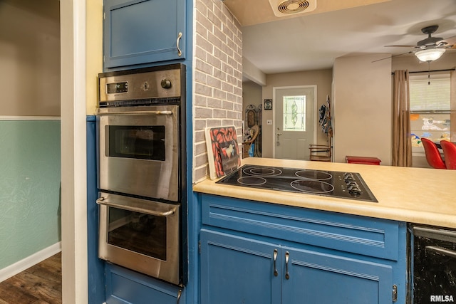 615 W Grand Ave, Carterville, IL 62918 - kitchen with blue cabinetry, black electric cooktop, double oven, and a ceiling fan