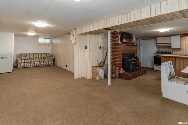 615 W Grand Ave, Carterville, IL 62918 - unfurnished living room with a wood stove, carpet, and wood walls