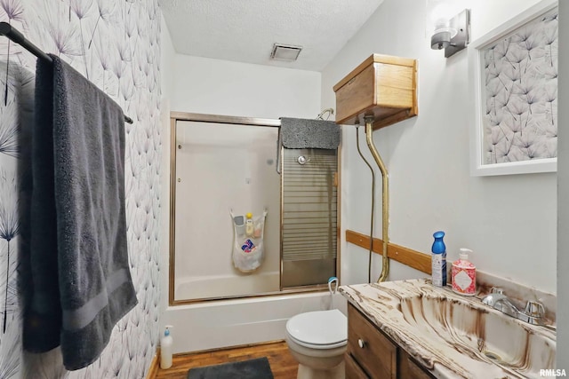 3414 Fillmore Ln, Davenport, IA 52806 - full bath featuring vanity, enclosed tub / shower combo, toilet, wood finished floors, and a textured ceiling
