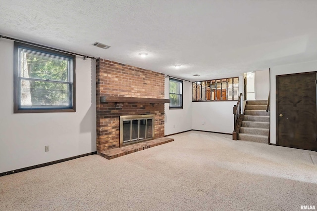 3845 Norwich Ct, Bettendorf, IA 52722 - unfurnished living room with stairs, baseboards, carpet, a fireplace, and a textured ceiling