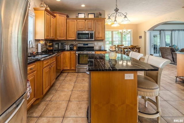 1404 Belle Terre Ct, Herrin, IL 62948 - kitchen with appliances with stainless steel finishes, a breakfast bar area, backsplash, arched walkways, and a sink