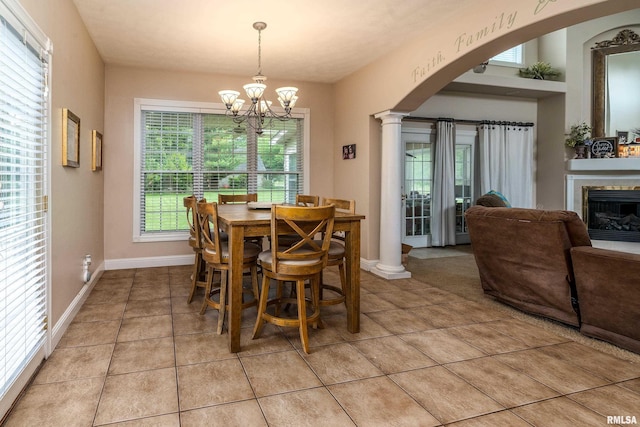 1404 Belle Terre Ct, Herrin, IL 62948 - dining space with arched walkways, a chandelier, light tile patterned floors, a fireplace, and ornate columns