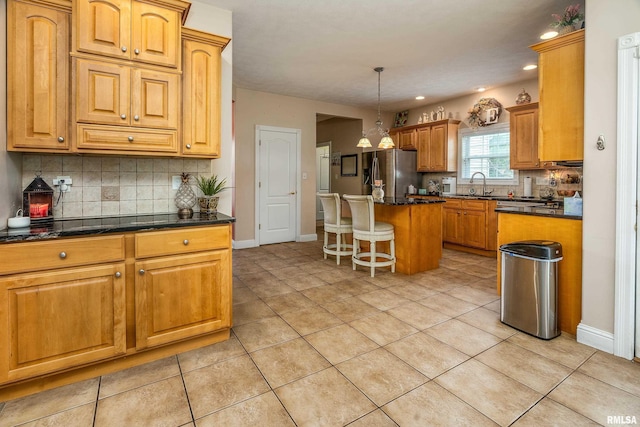 1404 Belle Terre Ct, Herrin, IL 62948 - kitchen with stainless steel fridge with ice dispenser, a sink, decorative backsplash, light tile patterned floors, and a kitchen bar