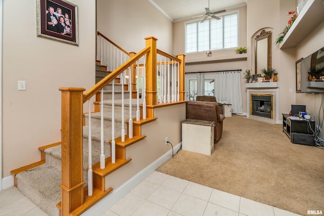 1404 Belle Terre Ct, Herrin, IL 62948 - stairway with a high ceiling, a ceiling fan, carpet flooring, baseboards, and a tiled fireplace