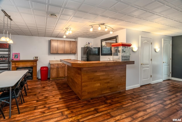 1404 Belle Terre Ct, Herrin, IL 62948 - kitchen featuring freestanding refrigerator, brown cabinets, dark wood-style flooring, a peninsula, and baseboards