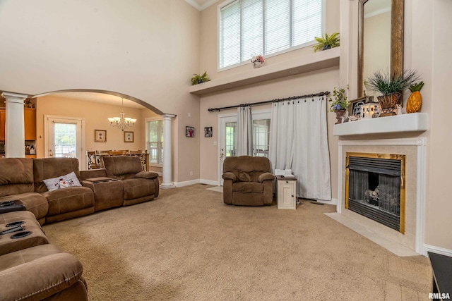 1404 Belle Terre Ct, Herrin, IL 62948 - living room with arched walkways, decorative columns, light colored carpet, a fireplace, and a chandelier