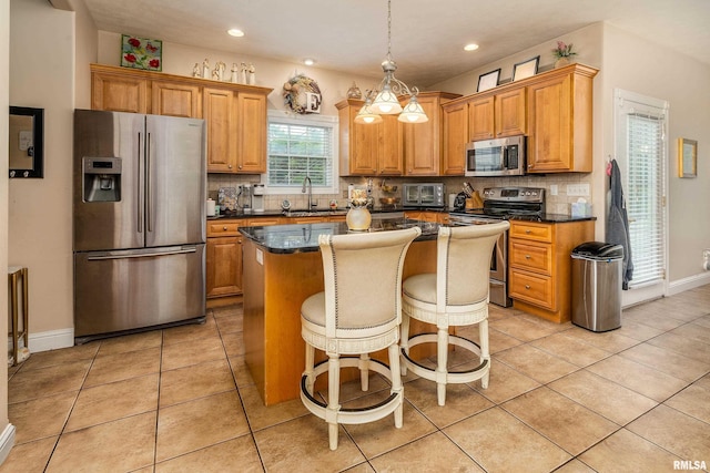 1404 Belle Terre Ct, Herrin, IL 62948 - kitchen with appliances with stainless steel finishes, a sink, a kitchen island, backsplash, and pendant lighting