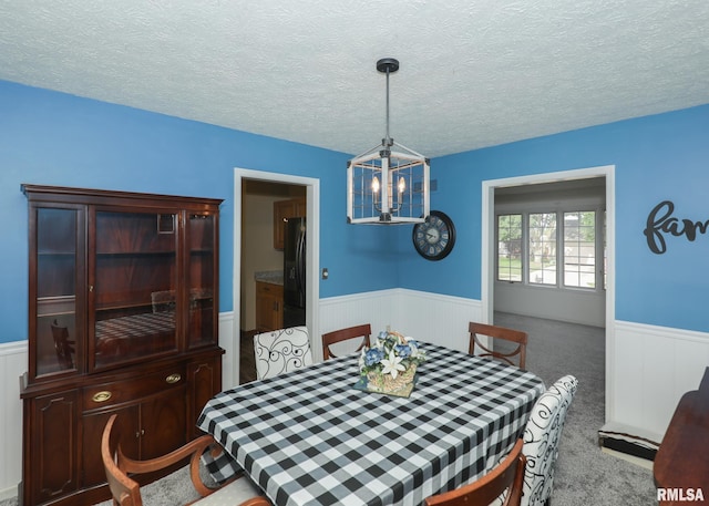 4760 Apple Valley Dr, Bettendorf, IA 52722 - dining room with wainscoting, a chandelier, a textured ceiling, and carpet