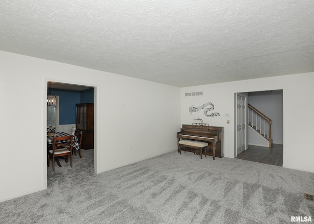 4760 Apple Valley Dr, Bettendorf, IA 52722 - carpeted empty room featuring a chandelier, stairway, and a textured ceiling