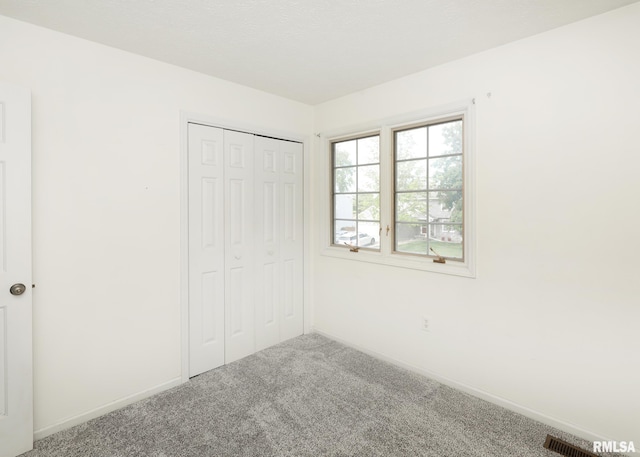 4760 Apple Valley Dr, Bettendorf, IA 52722 - unfurnished bedroom featuring carpet floors, a closet, and baseboards