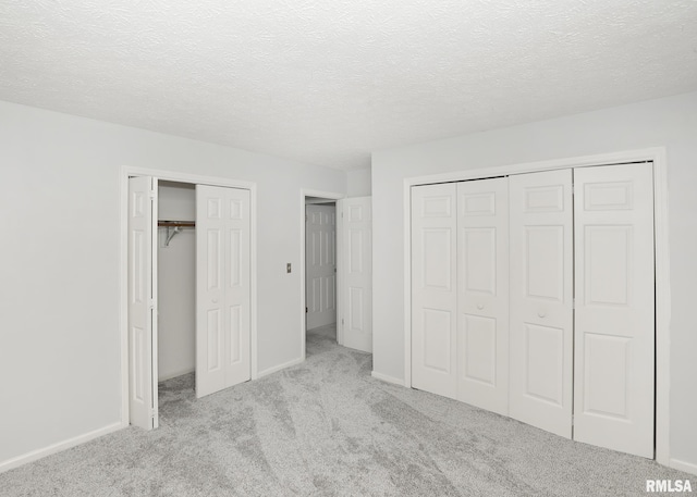 4760 Apple Valley Dr, Bettendorf, IA 52722 - unfurnished bedroom with multiple closets, carpet floors, a textured ceiling, and baseboards