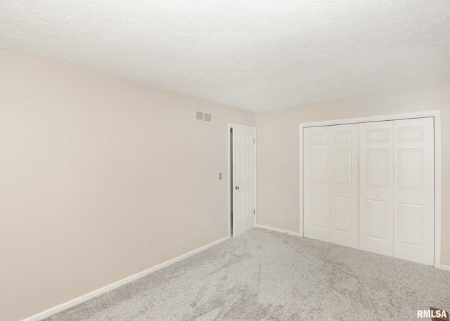 4760 Apple Valley Dr, Bettendorf, IA 52722 - unfurnished bedroom featuring carpet flooring, a closet, baseboards, and a textured ceiling