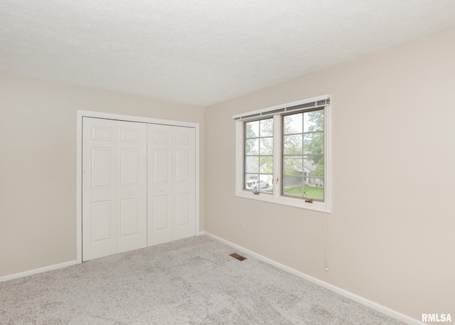 4760 Apple Valley Dr, Bettendorf, IA 52722 - unfurnished bedroom featuring carpet floors, a closet, a textured ceiling, and baseboards