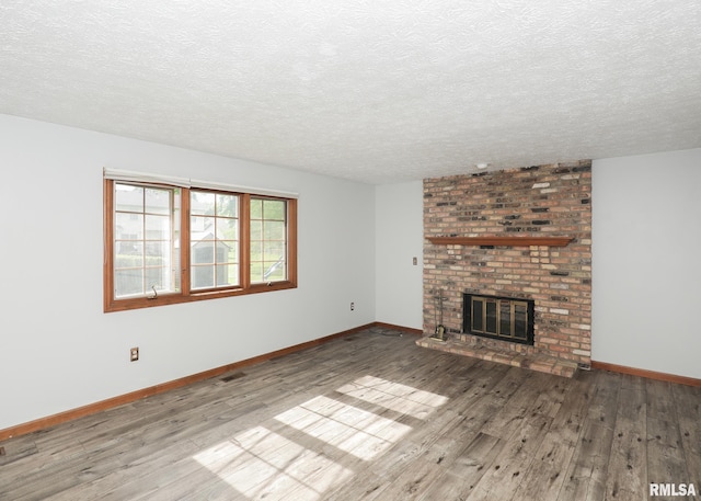 4760 Apple Valley Dr, Bettendorf, IA 52722 - unfurnished living room with hardwood / wood-style flooring, a textured ceiling, baseboards, and a fireplace