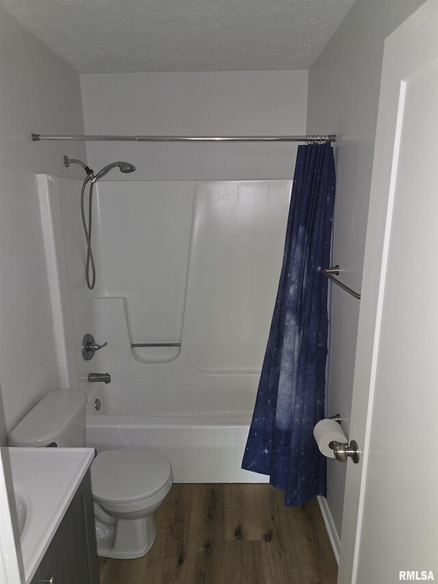 3920 13th St, Davenport, IA 52804 - bathroom featuring wood finished floors, toilet, shower / tub combo, vanity, and a textured ceiling
