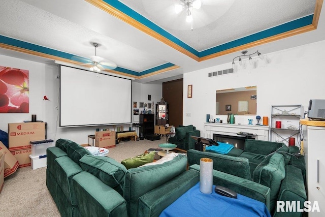 911 Cardinal Dr, Maquoketa, IA 52060 - cinema with ceiling fan, a raised ceiling, carpet floors, and a warm lit fireplace