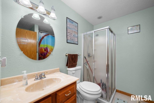 911 Cardinal Dr, Maquoketa, IA 52060 - bathroom with vanity, a shower stall, toilet, a textured ceiling, and a textured wall