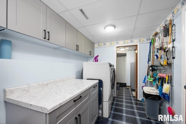 911 Cardinal Dr, Maquoketa, IA 52060 - laundry area with washing machine and clothes dryer, dark floors, and cabinet space