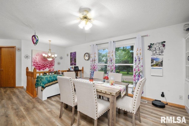 911 Cardinal Dr, Maquoketa, IA 52060 - dining space with light wood finished floors, a chandelier, a textured ceiling, ceiling fan, and baseboards