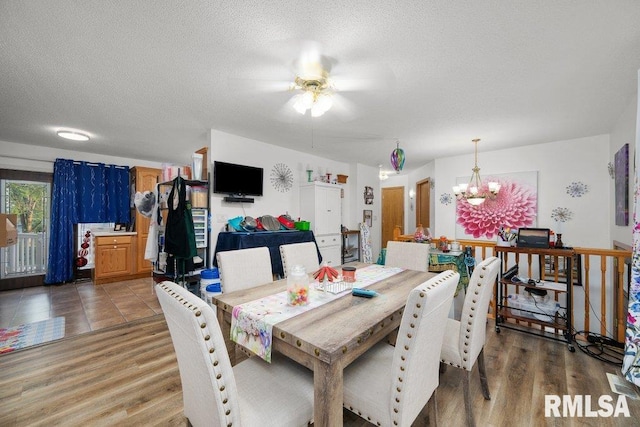 911 Cardinal Dr, Maquoketa, IA 52060 - dining room featuring a ceiling fan, a chandelier, light wood finished floors, and a textured ceiling