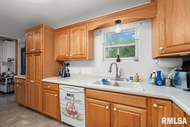 911 Cardinal Dr, Maquoketa, IA 52060 - kitchen featuring dishwasher, a sink, light countertops, light tile patterned flooring, and a textured ceiling