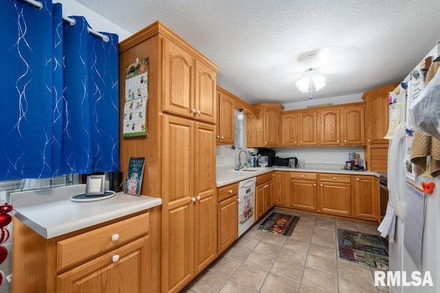911 Cardinal Dr, Maquoketa, IA 52060 - kitchen featuring a sink, white appliances, a textured ceiling, light countertops, and ceiling fan