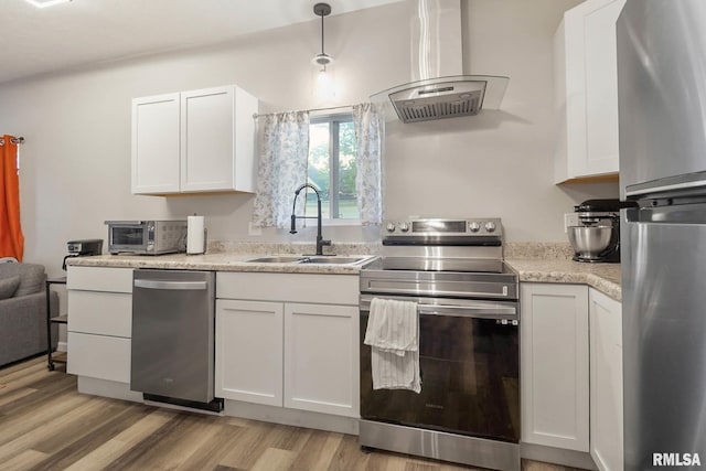 404 S 23rd St, Herrin, IL 62948 - kitchen with stainless steel appliances, island range hood, a sink, light wood-type flooring, and white cabinetry
