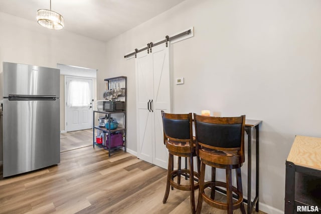404 S 23rd St, Herrin, IL 62948 - dining room with a barn door, wood finished floors, and baseboards