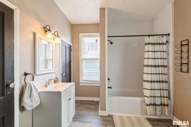 417 12th St, De Witt, IA 52742 - bathroom with wood finished floors, vanity, shower / bath combo, and baseboards