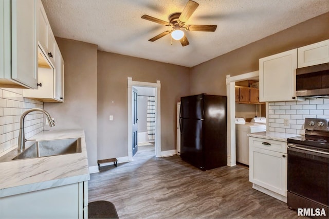 417 12th St, De Witt, IA 52742 - kitchen with freestanding refrigerator, range with electric stovetop, stainless steel microwave, a sink, and independent washer and dryer