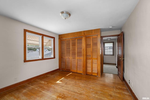 2920 Roosevelt St, Clinton, IA 52732 - unfurnished bedroom featuring hardwood / wood-style floors, baseboards, and multiple closets