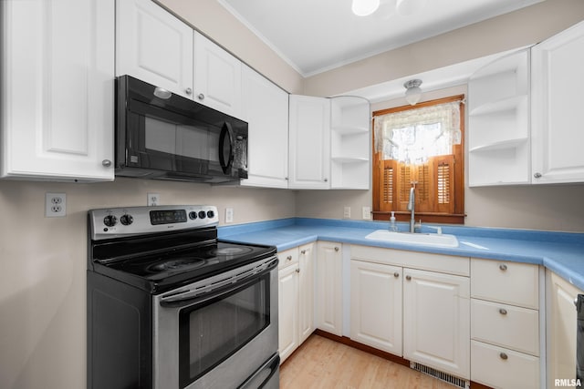 2920 Roosevelt St, Clinton, IA 52732 - kitchen with stainless steel range with electric stovetop, black microwave, a sink, open shelves, and ornamental molding