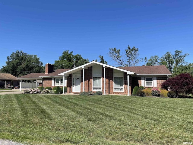 201 S Herrmann Dr, Ridgway, IL 62979 - ranch-style house featuring brick siding, a chimney, a front yard, a carport, and concrete driveway