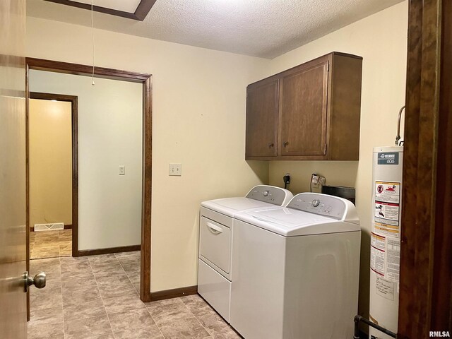 201 S Herrmann Dr, Ridgway, IL 62979 - washroom with washing machine and clothes dryer, gas water heater, cabinet space, a textured ceiling, and baseboards