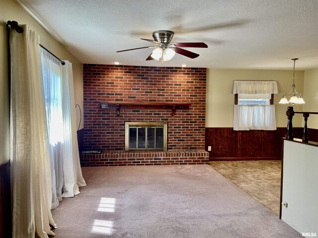 201 S Herrmann Dr, Ridgway, IL 62979 - unfurnished living room featuring healthy amount of natural light, ceiling fan, carpet floors, wainscoting, and a textured ceiling