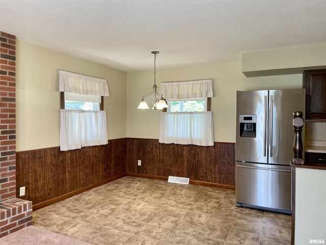201 S Herrmann Dr, Ridgway, IL 62979 - kitchen featuring stainless steel fridge with ice dispenser, a wainscoted wall, healthy amount of natural light, and wooden walls