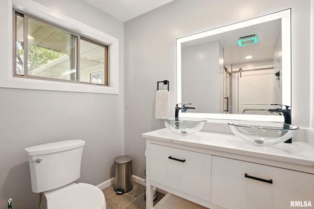 5760 Jenny Ln, Bettendorf, IA 52722 - full bath with double vanity, tile patterned flooring, toilet, baseboards, and a shower
