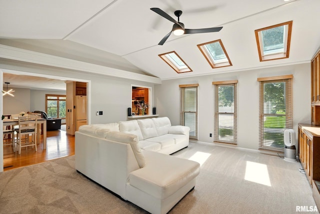 5760 Jenny Ln, Bettendorf, IA 52722 - living area with lofted ceiling, light colored carpet, a skylight, a ceiling fan, and healthy amount of natural light