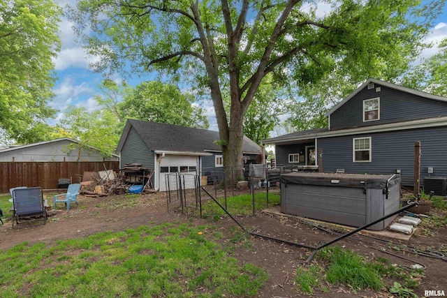 521 E Park St, Geneseo, IL 61254 - rear view of property featuring a hot tub, central AC unit, a detached garage, and an outdoor structure