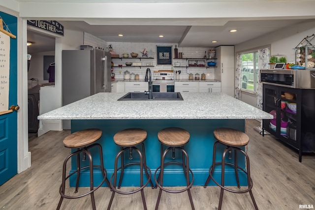 521 E Park St, Geneseo, IL 61254 - kitchen featuring open shelves, a sink, white cabinets, light wood finished floors, and recessed lighting
